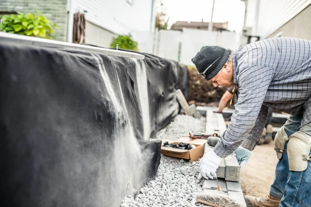 retaining wall builder putting up blocks